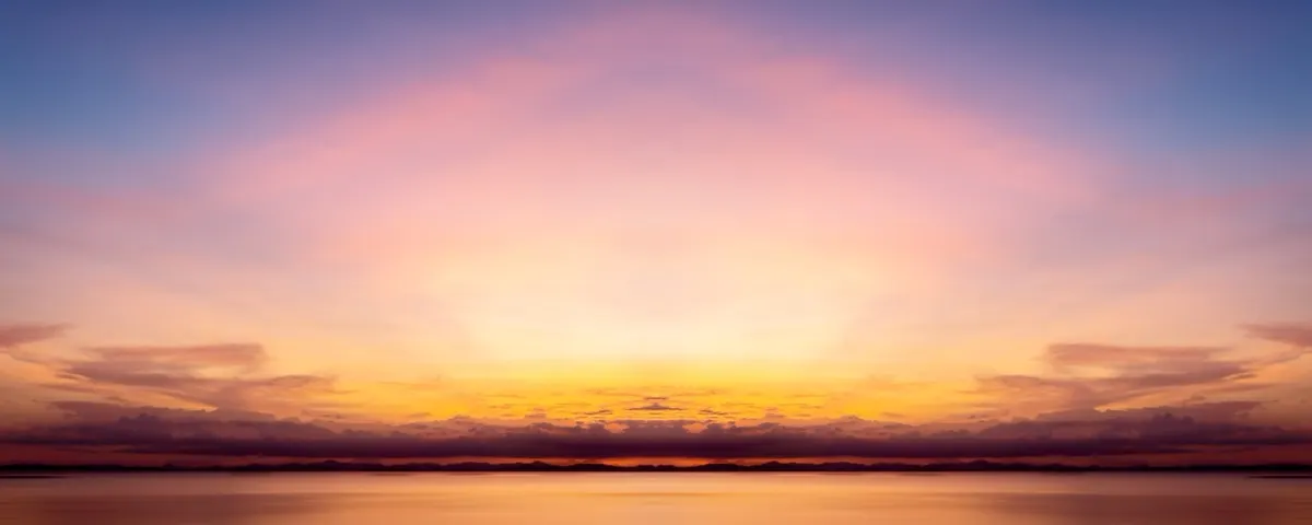 A wide, tranquil sky transitioning from deep twilight into soft golden and rose hues at sunrise, reflecting the profound inner shift that signals the end of the Dark Night